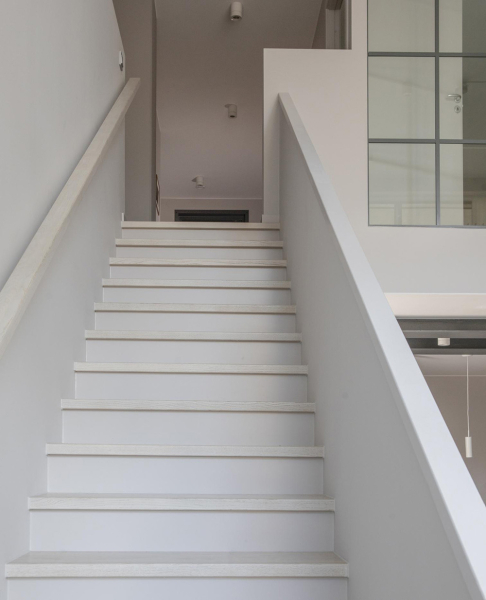 Спокойный интерьер скандинавского лофта с черной кухней и антресолью