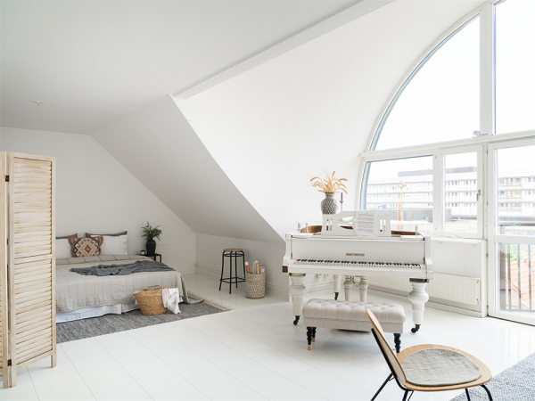 Белоснежная мансардная квартира с арочным окном и роялем