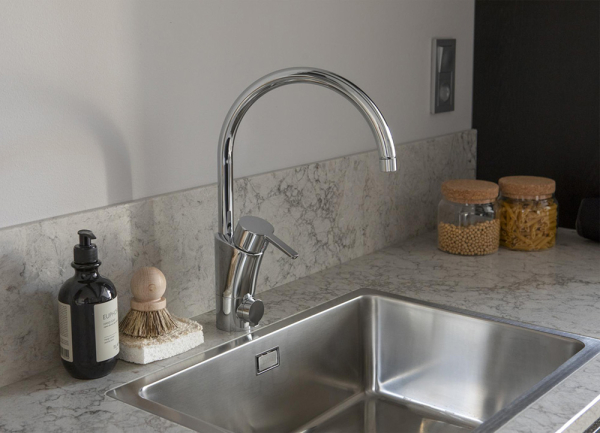 Спокойный интерьер скандинавского лофта с черной кухней и антресолью