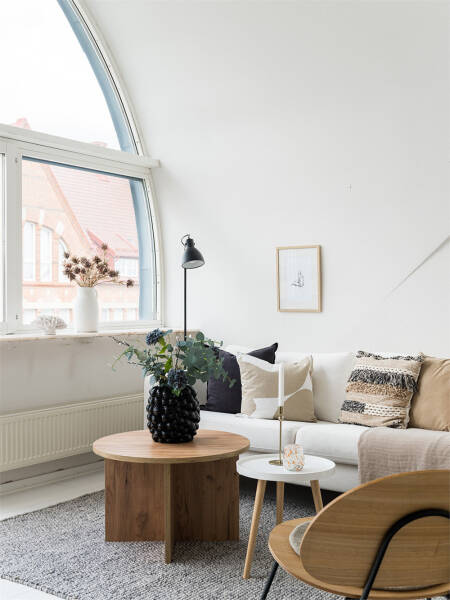 Белоснежная мансардная квартира с арочным окном и роялем