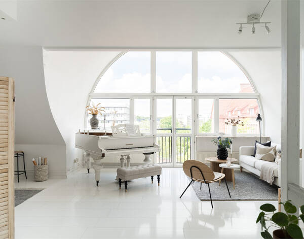 Белоснежная мансардная квартира с арочным окном и роялем