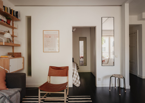 Маленькая шведская квартира с тёмным полом и спальней в нише (35 кв. м)